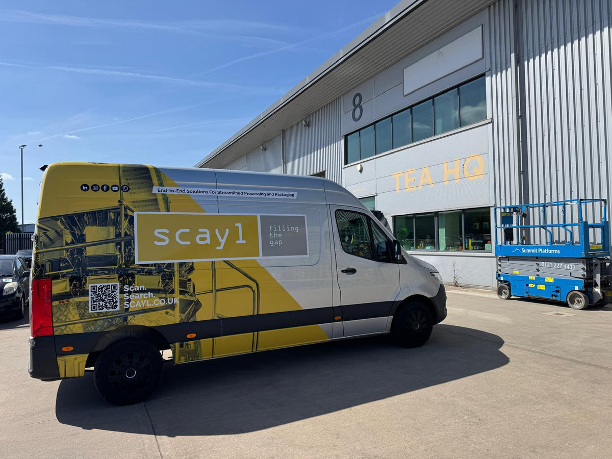 Van with 'scay1' branding parked in front of a building with 'TEA HQ' signage.