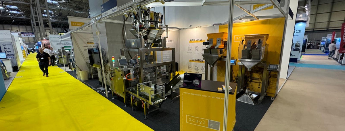 Exhibition stand with yellow and grey colour scheme in a large indoor venue