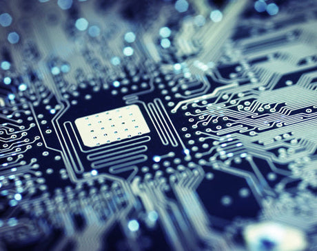 Close-up of a blue-toned computer motherboard, highlighting intricate circuit pathways and a central chip, conveying a sense of modern technology.