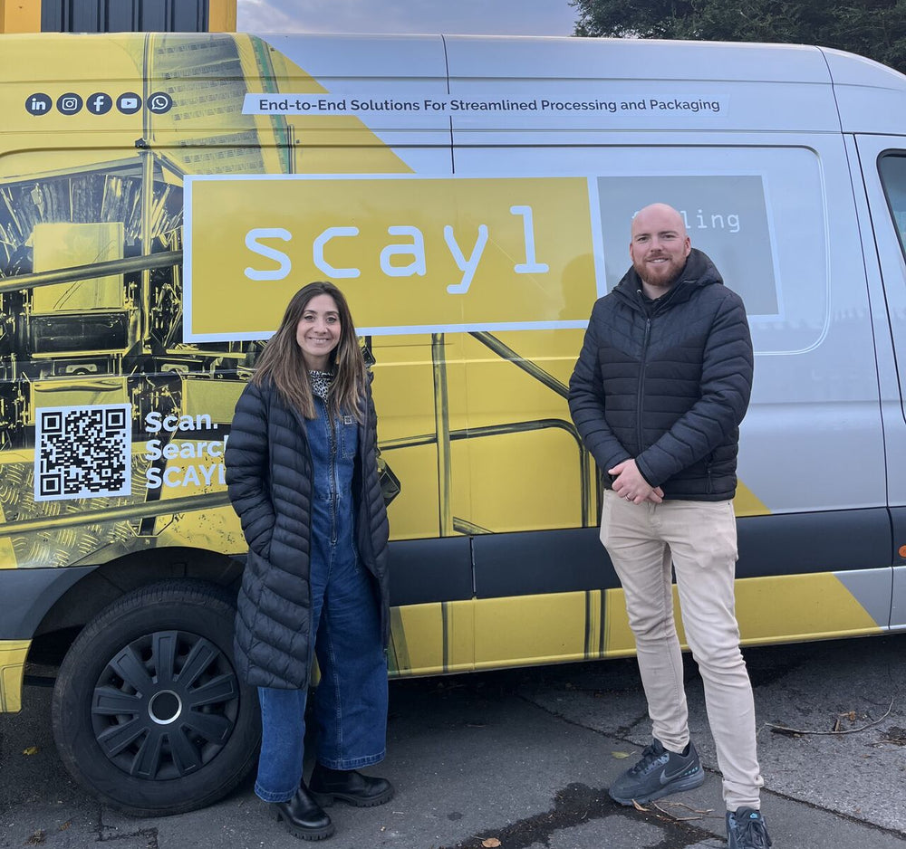 Two people standing in front of a van with 'scayl' branding.